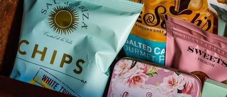 A drawer containing various snack items including chips, popcorn, and sweets.