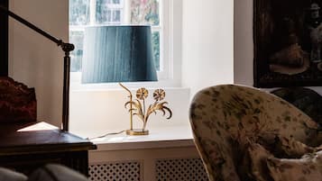 A room with a window, a lamp, and a chair.