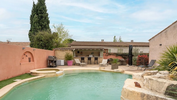 A swimming pool with a stone wall, lounge chairs, and a barbecue area. - Les dames de Mollégès, at the gateway to the Alpilles, 10 minutes from St Rémy de Provence (Mollégès)