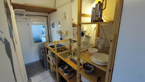 A compact kitchen with a wooden countertop, a sink, and various kitchen utensils.
