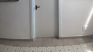 A hallway with a door, a map, and a whale decoration.