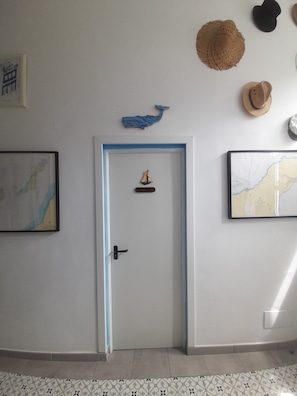 A hallway with a door, a map, and a whale decoration.