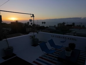 A rooftop terrace with a view of the sunset, potted plants, and the name 'LA CASITA AZUL' on the wall. - The Cabin, Nano study (Puerto de la Cruz)