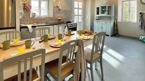 A spacious kitchen with a dining area, featuring a large island, modern appliances, and ample natural light.