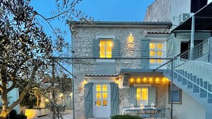 A stone building with a covered patio, outdoor seating, and a staircase.