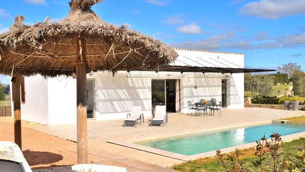 A modern house with a pool, outdoor seating, and a thatched roof structure. - Son Alcaines Petit 249 cosy finca with private pool, terrace, barbecue and WiFi (Sineu)
