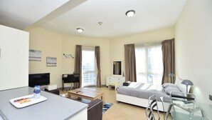A modern hotel room with a bed, bedside table, desk, and a TV. - Alia -Bright furnished studio near metro (Dubai)