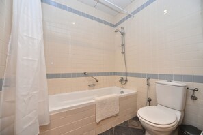 A bathroom with a bathtub, toilet, and shower.