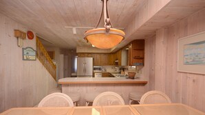 A wooden interior with a dining area, kitchen, and a staircase. - Beautiful, oceanfront 5 bedroom townhome! (Ocean City)