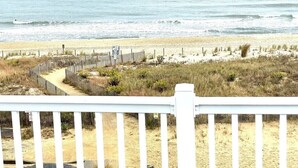 A beach view with a wooden fence and a pathway leading to the water. - Beautiful, oceanfront 5 bedroom townhome! (Ocean City)