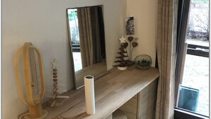 Une chambre moderne avec un bureau en bois, un miroir et une fenêtre avec des rideaux.