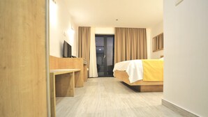 A hotel room with a bed, a desk, a television, and a sliding door leading to a balcony. - B&B Boutique Eluize Dubrovnik (Dubrovnik)