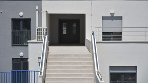 A building with a staircase leading to a door, a window with a metal railing, and a garage door. - B&B Boutique Eluize Dubrovnik (Dubrovnik)