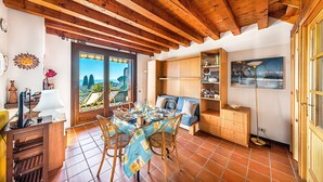 Ein gemütlicher Essbereich mit einem Tisch für zwei Personen, Holzstühlen und Blick durch eine Tür nach draußen.