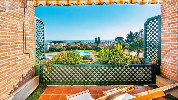 Eine Terrasse mit Blick auf ein Schwimmbecken und sanfte Hügel in der Ferne.