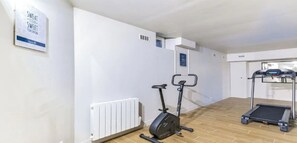 A fitness area with an exercise bike, a treadmill, and a wall-mounted sign. - Top of the range in Montrogueil -330sqm 5br family villa-sensational! (Paris)