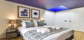 A neatly arranged bedroom with a bed, bedside lamps, a nightstand, and a door. - Top of the range in Montrogueil -330sqm 5br family villa-sensational! (Paris)