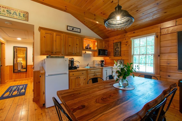 Kitchen features a large table, sink, stove, refrigerator, and microwave.