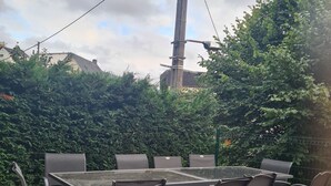 Eine Terrasse im Freien mit Holzdeck, einem rechteckigen Tisch und sechs Stühlen.