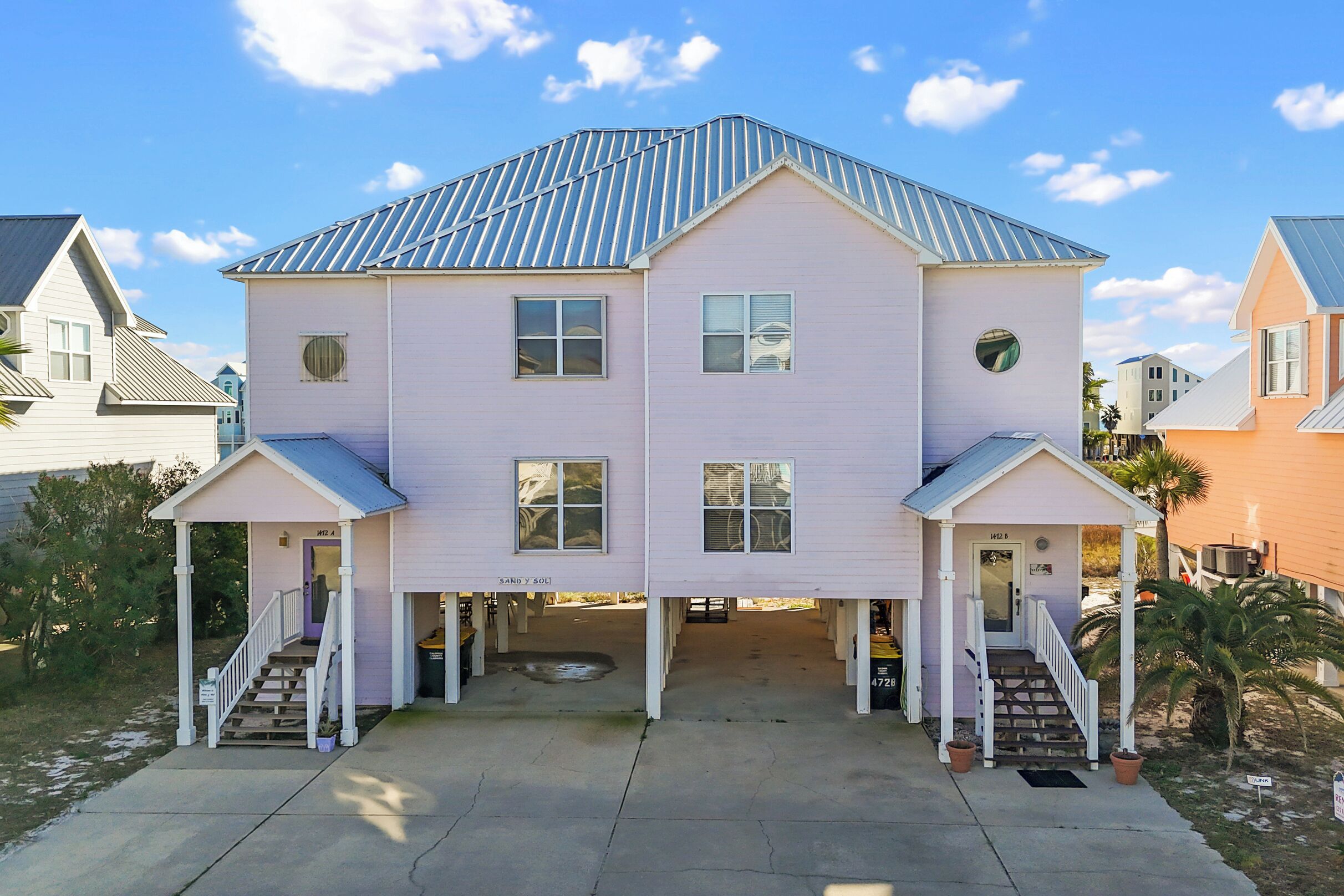 A two-story building with a gabled roof, a covered front porch, and a garage entrance.