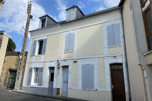 La maison est la porte de gauche avec les fenêtres ouvertes.