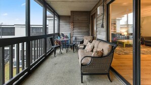 Ein Balkon mit einer Couch, Stühlen und einem Tisch.