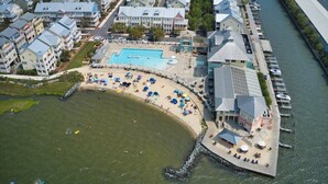 An aerial view of a coastal hotel with a swimming pool, beach area, and marina. - Beautiful 3 BR 2 BA Unit in Amenity Filled Sunset Island (Ocean City)