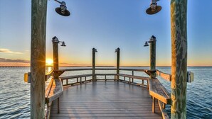 A wooden pier with railings and benches, overlooking a calm body of water during sunset. - Beautiful 3 BR 2 BA Unit in Amenity Filled Sunset Island (Ocean City)