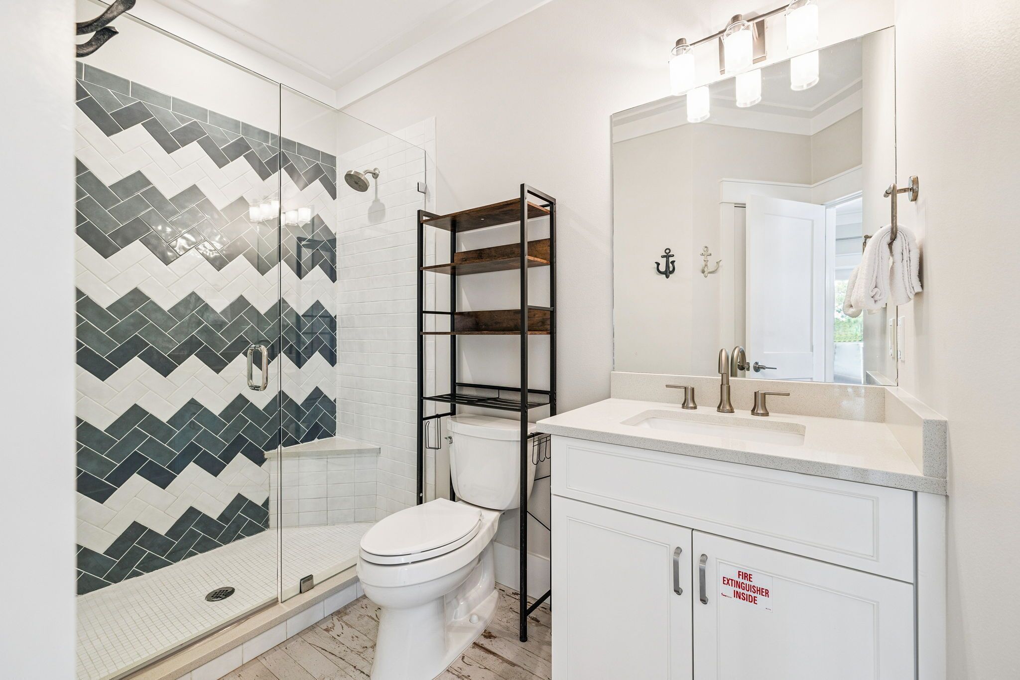 Een moderne badkamer met douche, toilet, wastafel en spiegel.