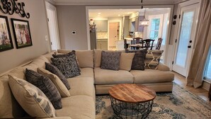 A living room with a sectional sofa, a coffee table, and a patterned rug.