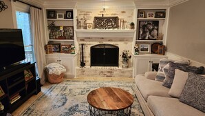 A living room with a fireplace, a television, a sofa, and a coffee table.