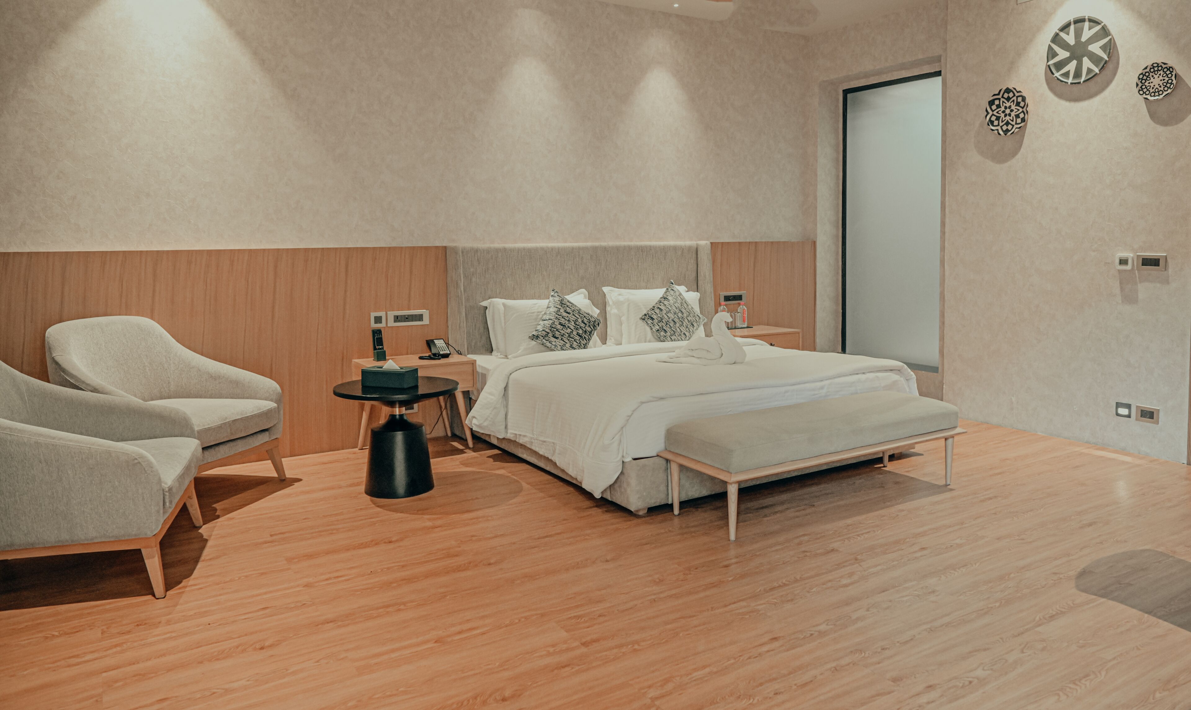 A modern bedroom with a bed, bedside tables, a chair, and a small table.