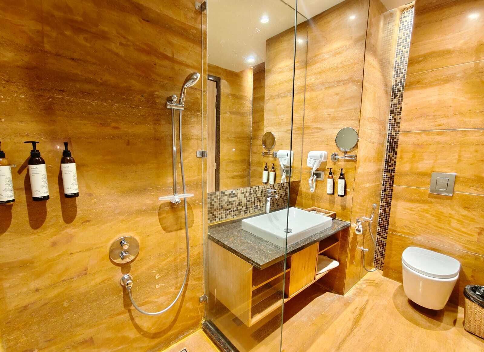 A modern bathroom with a glass-enclosed shower, a vanity with a sink, and a toilet.