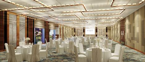 A spacious banquet hall with round tables, white chairs, and a carpeted floor.