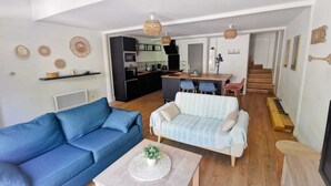 A modern living room with a blue sofa, a striped sofa, and a coffee table with a plant.