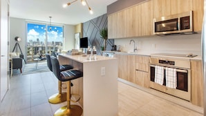 Een moderne keuken met een centraal eiland, roestvrijstalen apparatuur en uitzicht over de stad.