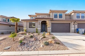 A residential house with a garage, a landscaped front yard with rocks and plants, and a clear sky. - Escondido 2343 & 2355 Retreat, Connected homes with 10 Bedrooms, sleeps 40, and endless amenities (Washington)