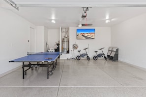A room with a ping pong table, a water heater, and two electric scooters. - Escondido 2343 & 2355 Retreat, Connected homes with 10 Bedrooms, sleeps 40, and endless amenities (Washington)