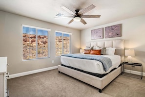 A bedroom with a bed, a ceiling fan, two windows with blinds, a headboard, and wall art. - Escondido 2343 & 2355 Retreat, Connected homes with 10 Bedrooms, sleeps 40, and endless amenities (Washington)