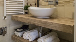 A modern bathroom with a large white sink, wooden shelves, and a towel rack. - Alloggio Turistico Port Inn (Civitavecchia)