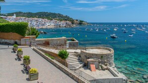 A coastal town with a historic fort, clear blue sea, and boats.
