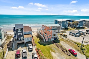 A coastal residential area with multi-story buildings, a beach, and parked cars.