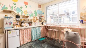 Una cocina con refrigerador, lavamanos y ventana.