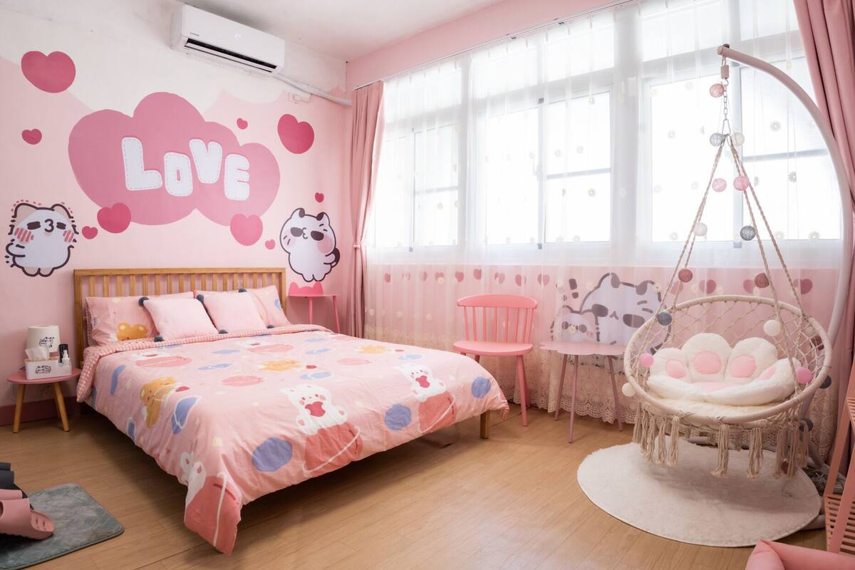 Un dormitorio en tonos rosados con una cama, una silla colgante y una mesita.