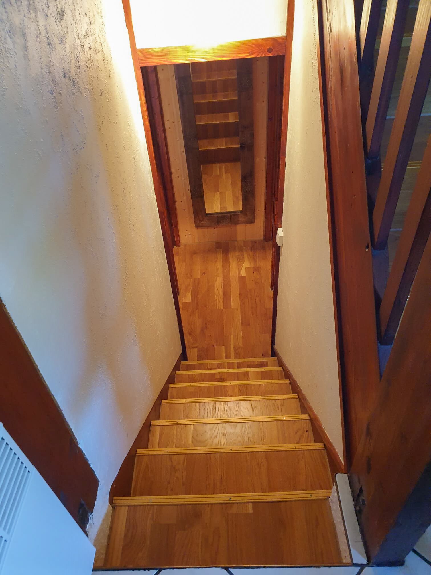 Eine Holztreppe mit Geländer und einer kleinen Aussichtsplattform.