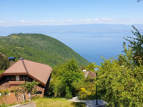 Un hôtel situé sur une colline, offrant une vue sur un lac et des montagnes.