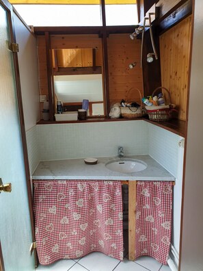 Une petite salle de bain avec un lavabo, un miroir et des éléments décoratifs en bois.