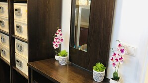 Un escritorio de madera con un espejo, plantas en macetas y un teléfono.