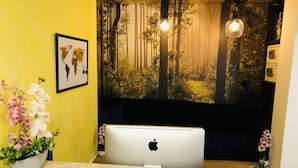 Un mostrador de recepción con un MacBook blanco de Apple, un mapa mundial y orquídeas.