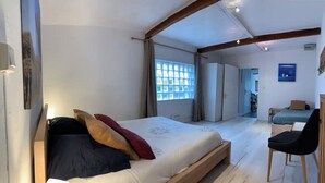 Een slaapkamer met een bed, een stoel, een kledingkast en een raam.